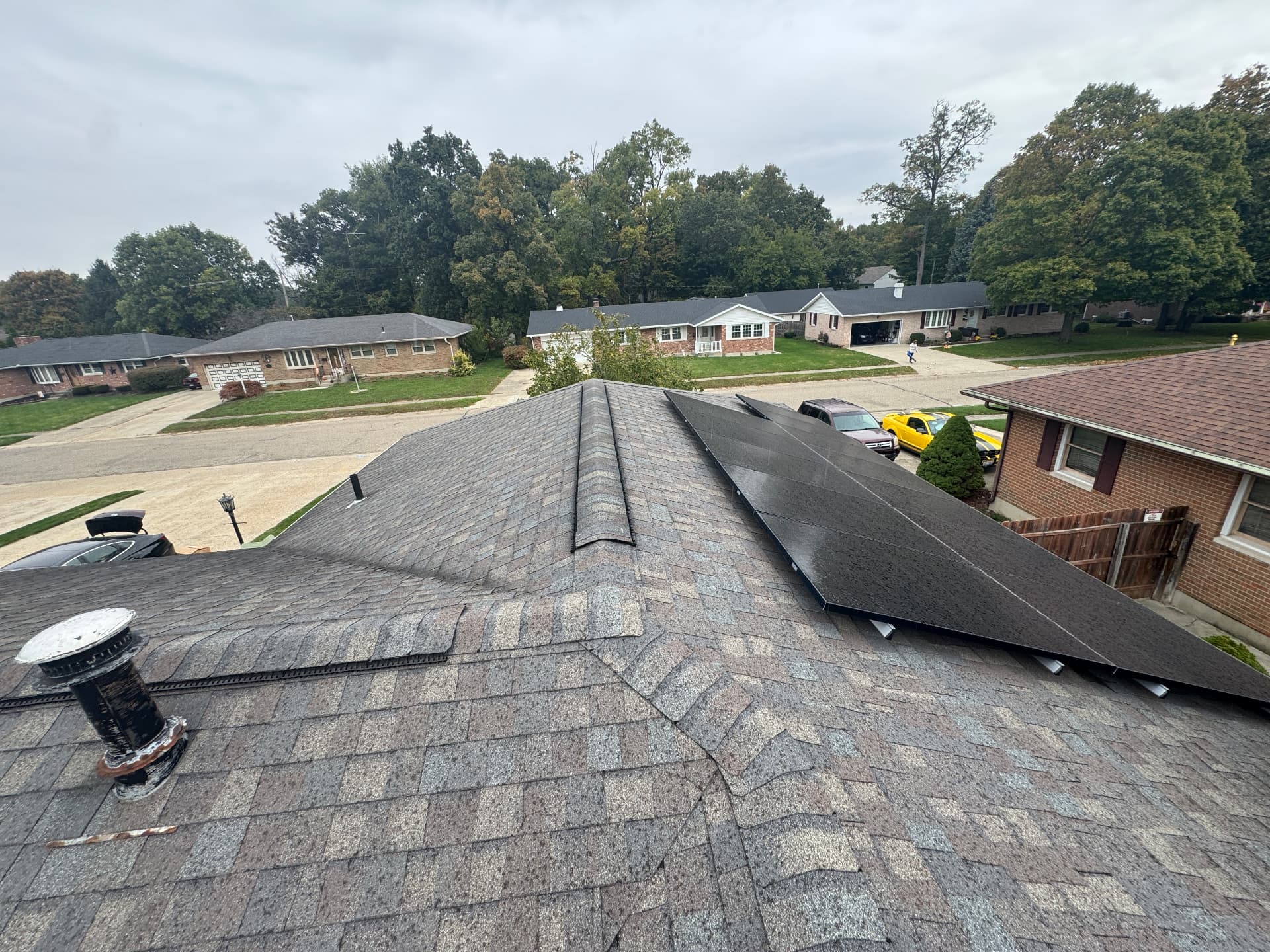 Before: worn, weathered shingle roof with solar array